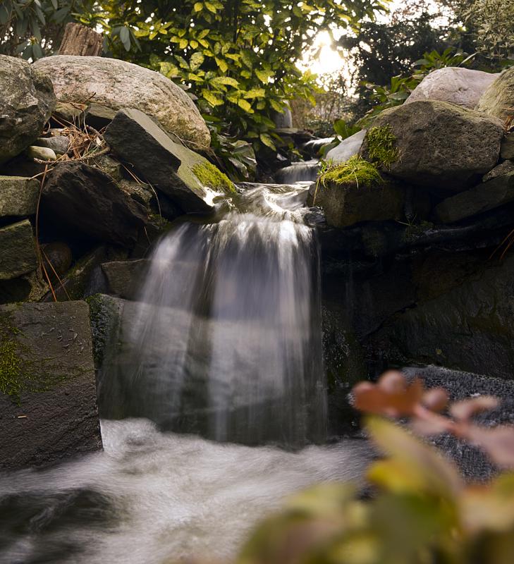 A waterfall adds sound and visual interest to a garden.